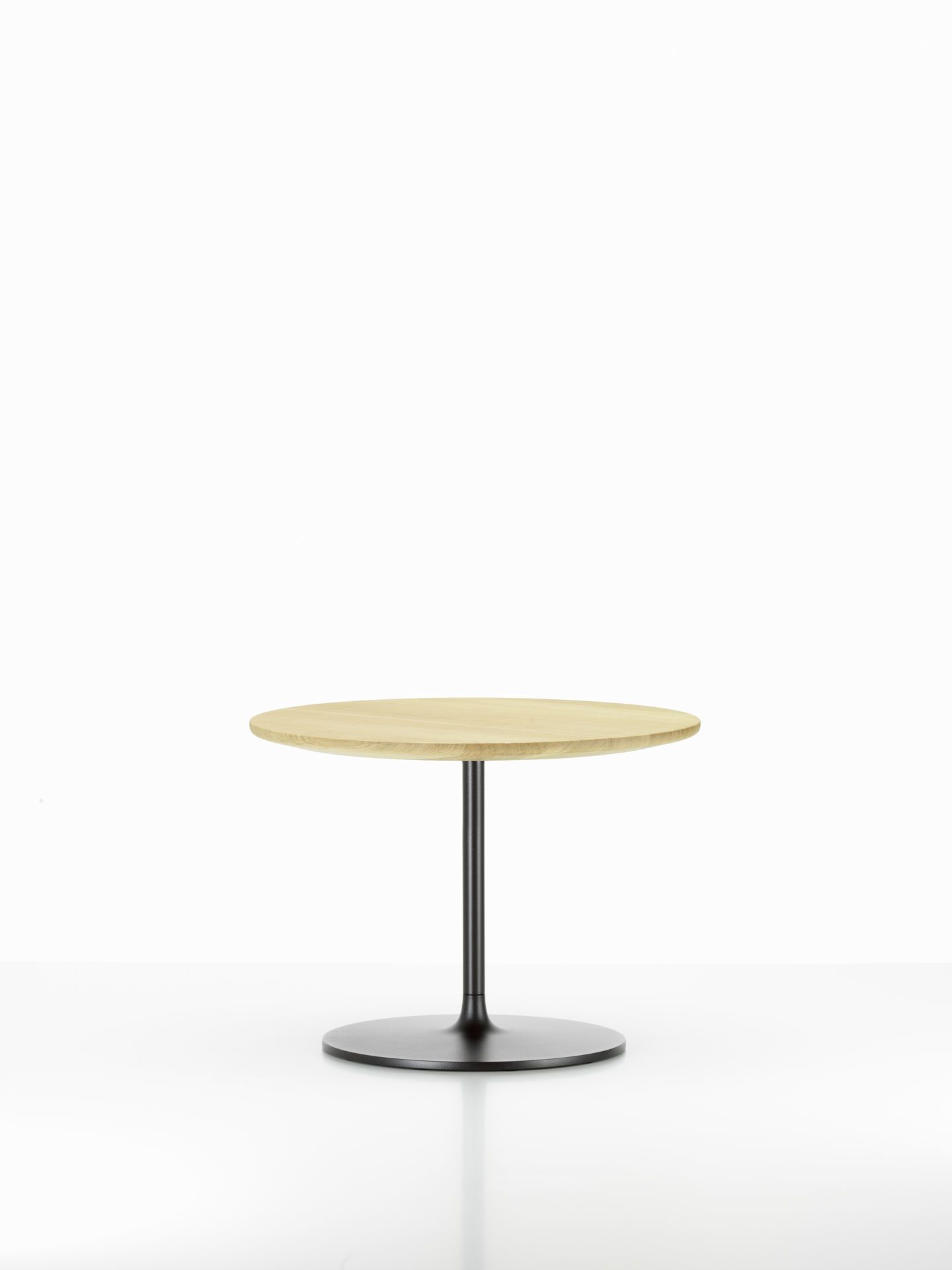Vitra Occasional Low Table Beistelltisch mit runder, heller Holzplatte und schwarzem Fuß.