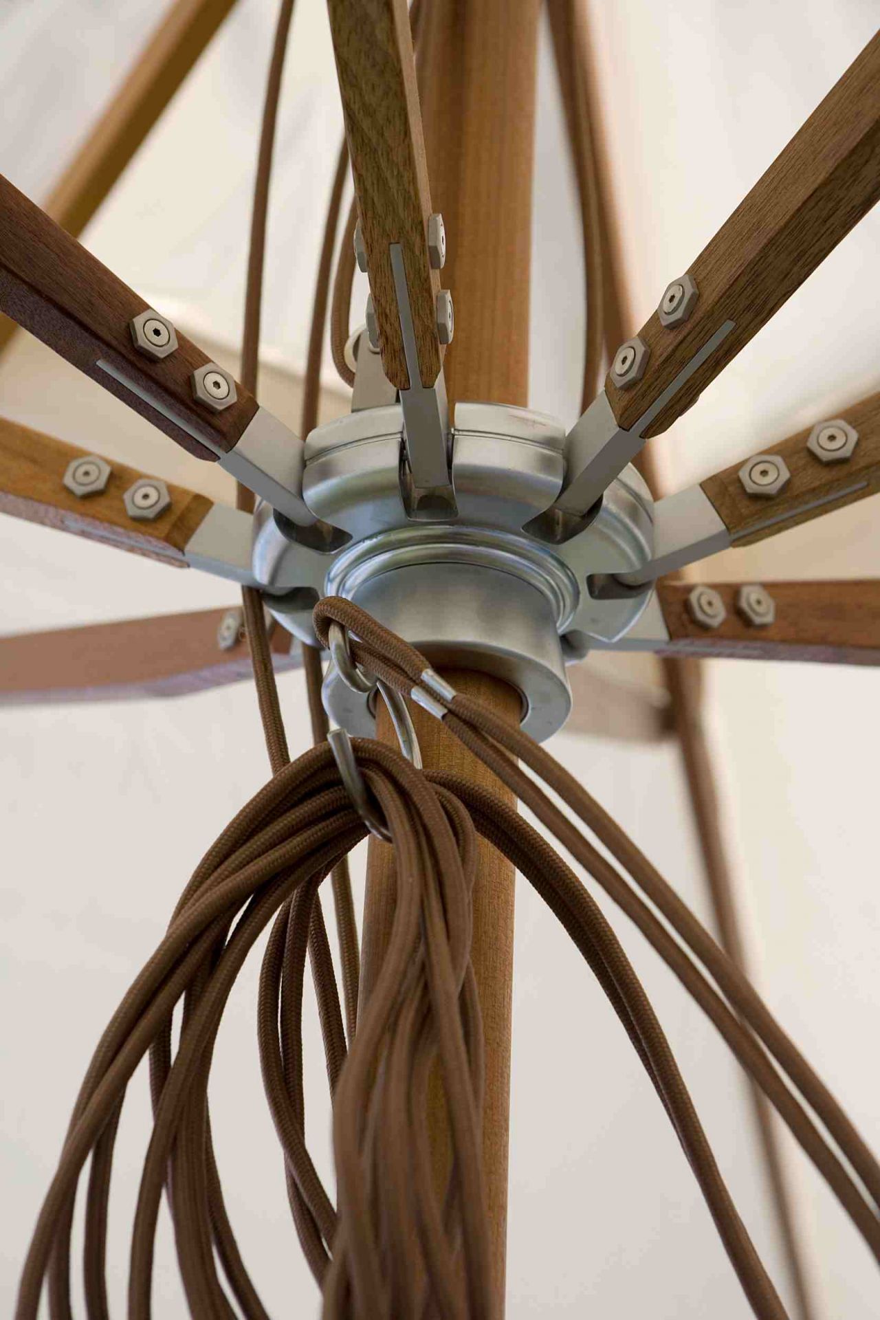 Detailaufnahme Atlantis Sonnenschirm: Holzgestell, silberne Mechanik und braune Kordeln. Hochwertiger Sonnenschutz für Garten und Terrasse.