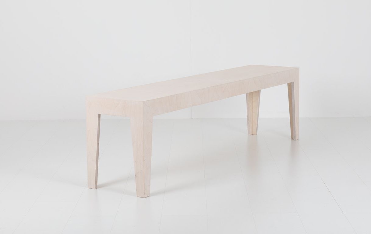 Helle Holzbank "Hilde" mit vier Beinen vor weißem Hintergrund, minimalistisches Design.