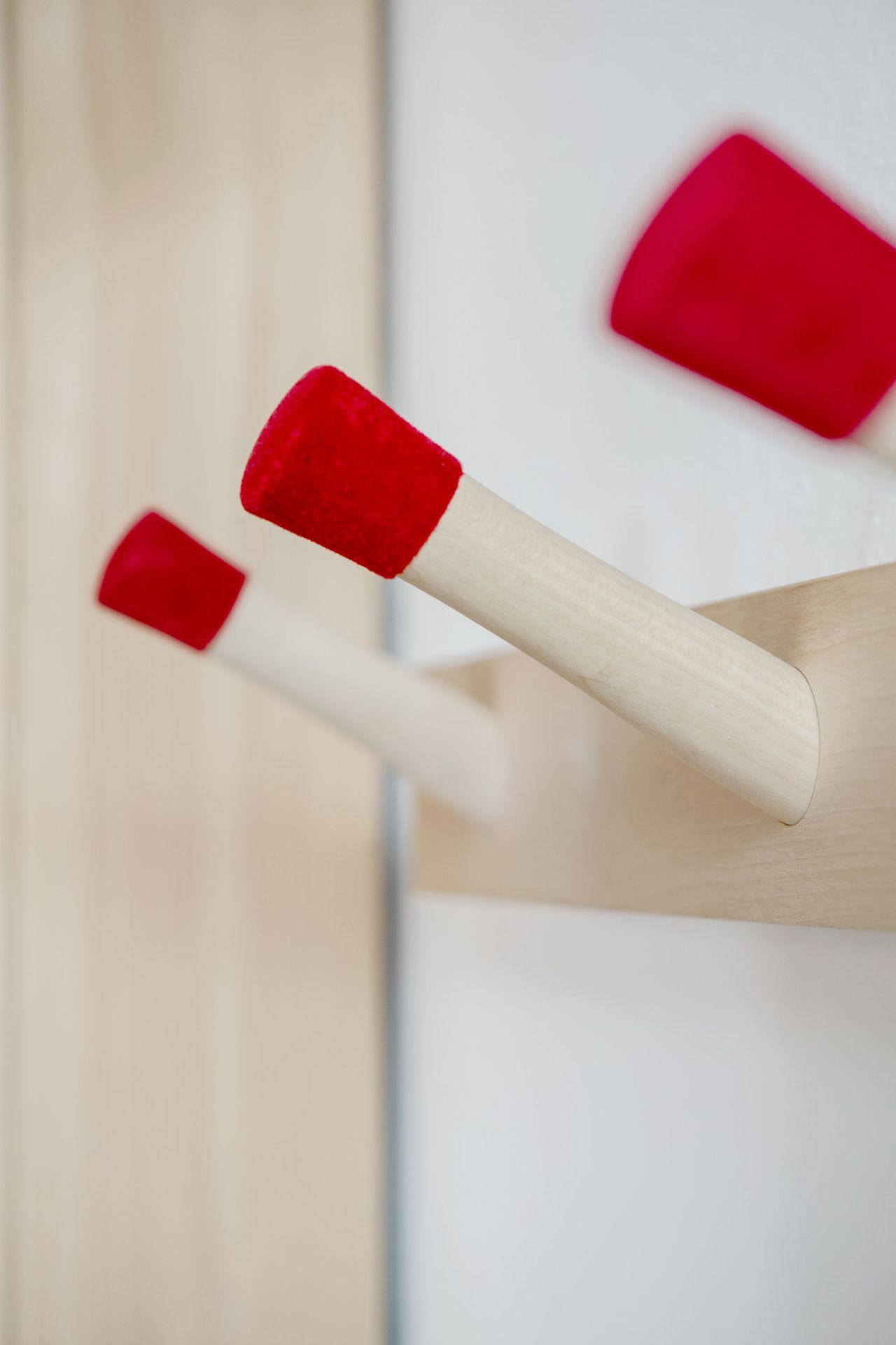 Detailansicht der Rechenbeispiel Hakenleiste von Nils Holger Moormann mit roten Haken.