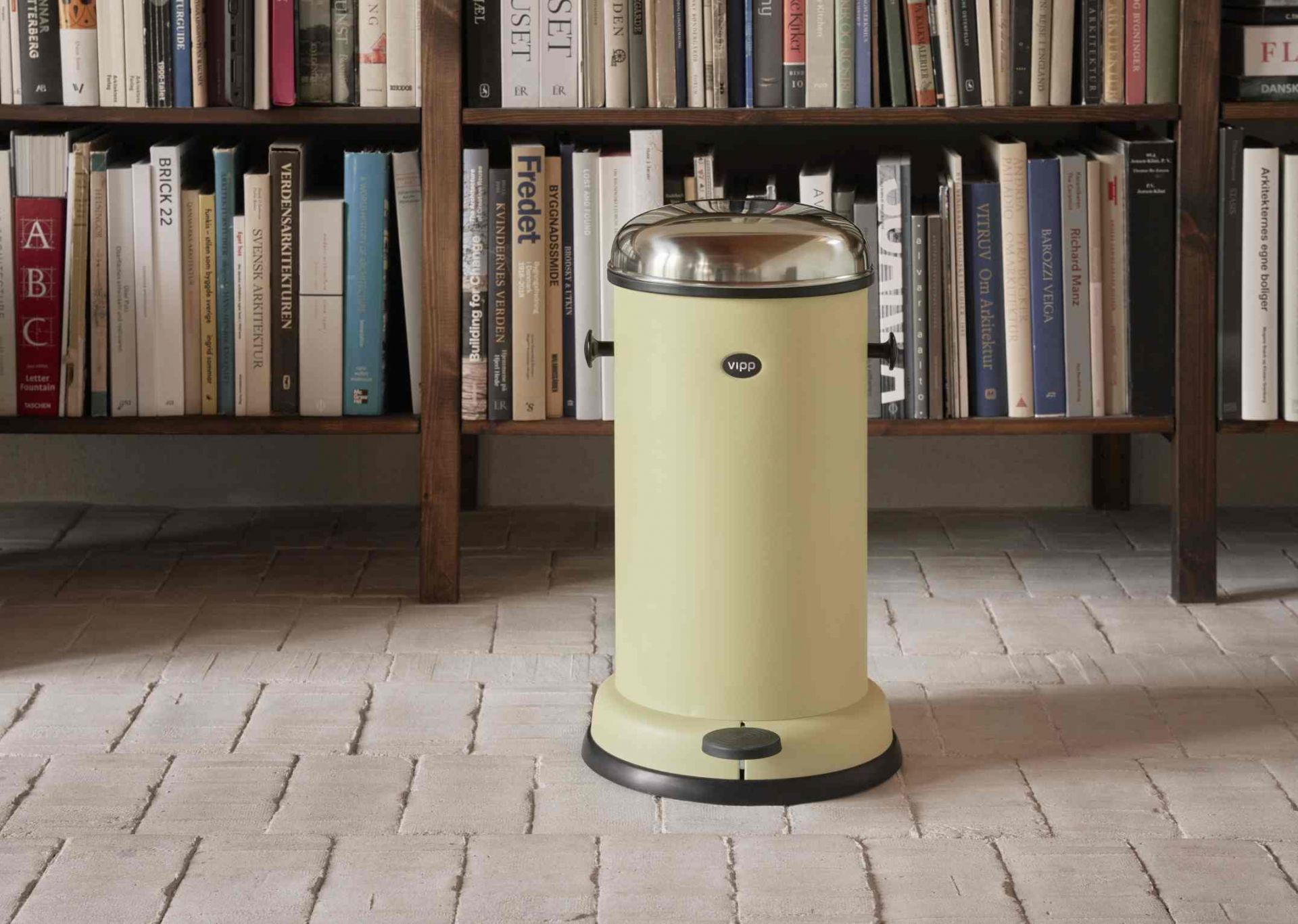 Marie's Yellow Vipp Treteimer: Gelber Mülleimer mit Fußpedal und Edelstahldeckel vor Bücherregal. Design Treteimer.
