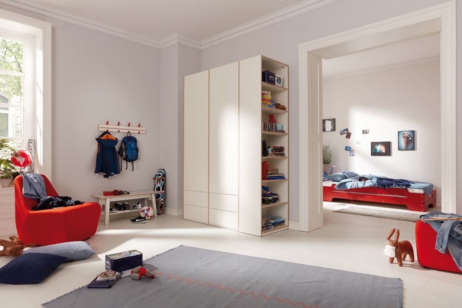 Kinderzimmer mit Müller Möbelwerkstätten Regal, Kleiderschrank und offenem Stirnelement für Spielzeug und Bücher.