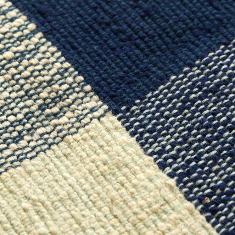 Detailaufnahme des Nobsa Rug Teppichs mit marineblauen, hellgrünen und cremefarbenen Karomuster. Hochwertige Textur des Teppichs.