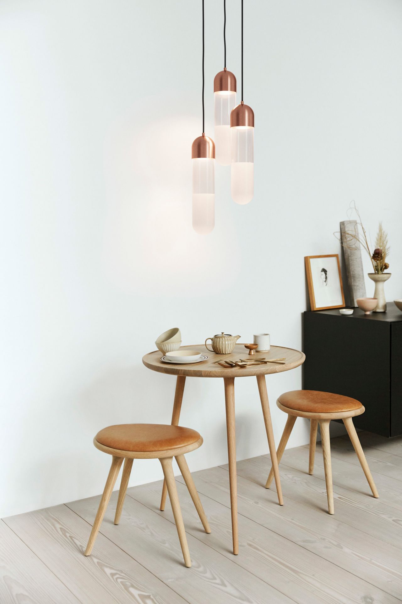 Zwei Stool Barhocker aus geseifter Eiche mit Ledersitz an einem Holztisch in einem minimalistischen Raum.