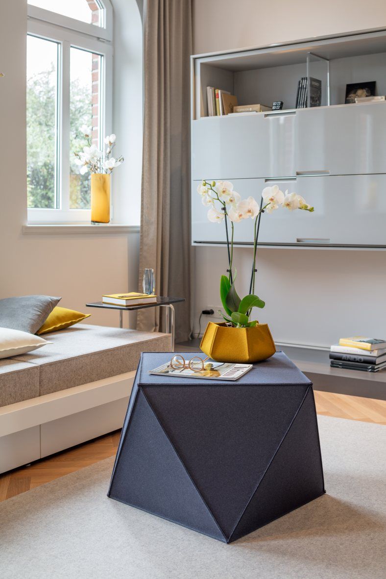 Blauer Diamond Sitzhocker von Hey Sign im Wohnzimmer mit Orchidee und Magazin.