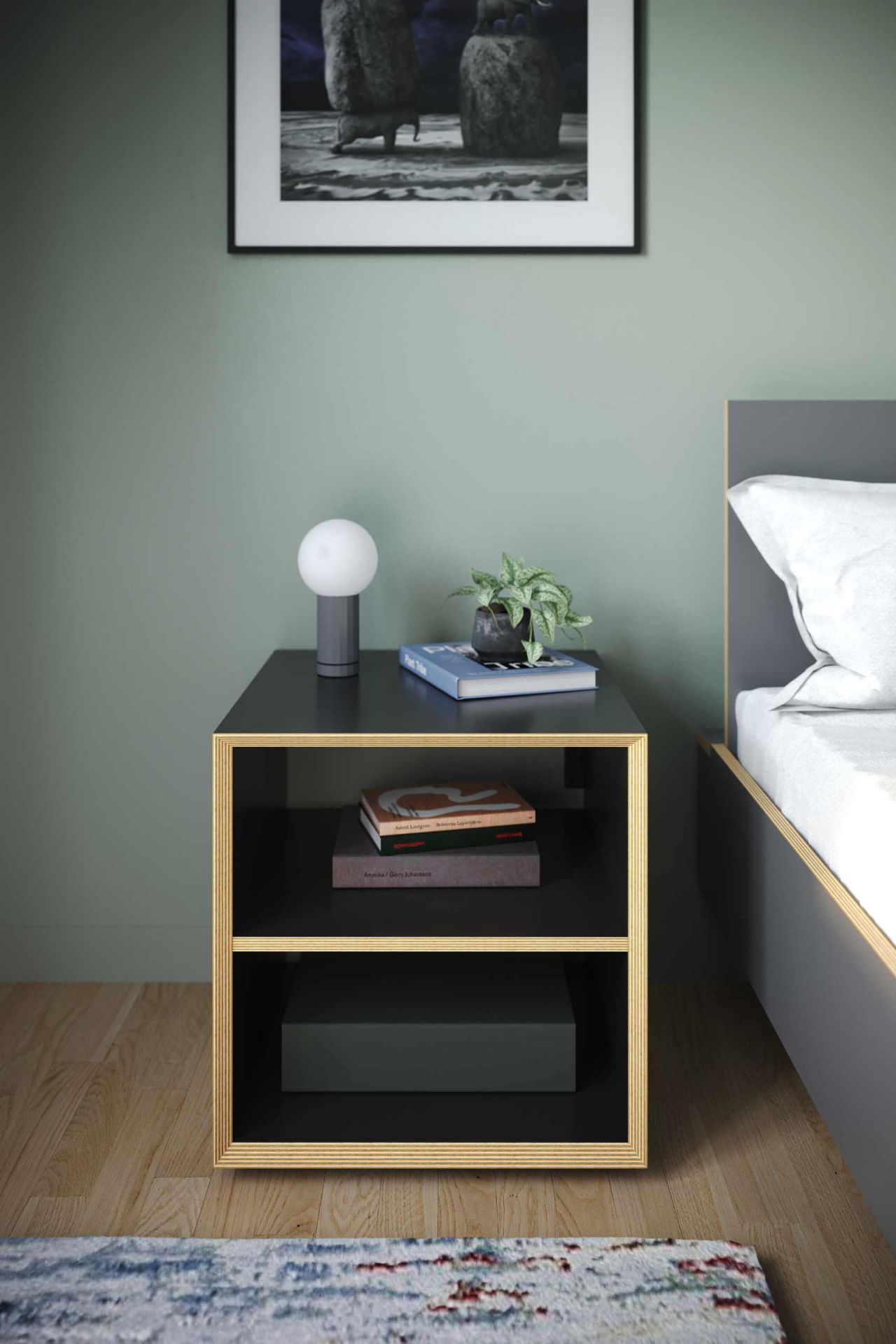 Vertiko Dice Nachttisch von Müller Möbelwerkstätten in Schwarz mit Lampe, Büchern und Pflanze auf Ablageflächen.