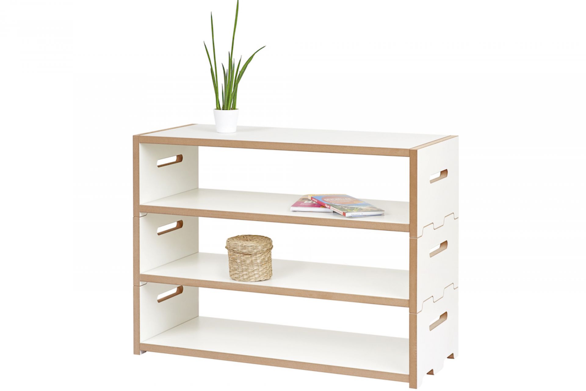 Tojo Hochstapler Regalsystem: Niedriges, weißes Holzregal mit drei Fächern, dekoriert mit Pflanze, Büchern und Korb.