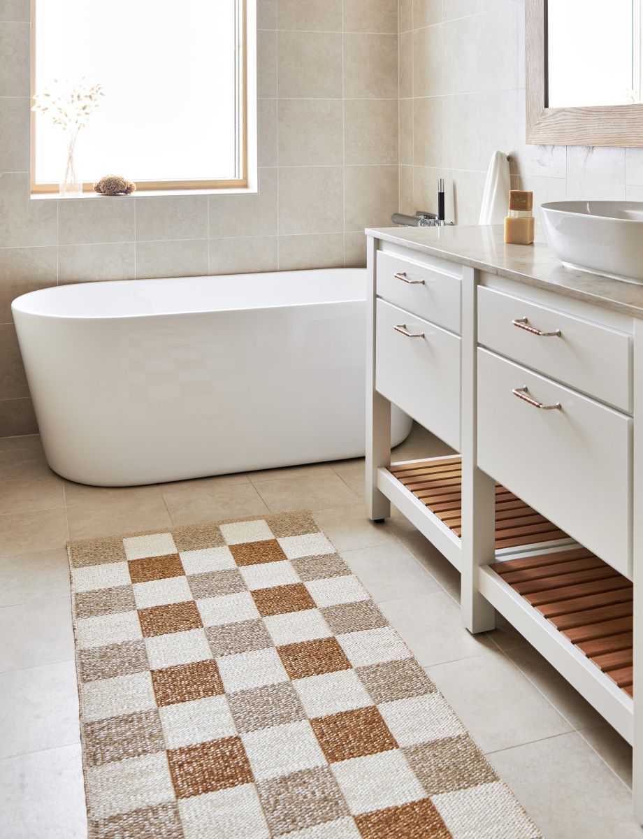 Badezimmer mit Pappelina Teppich Pix in Army, 70x160cm, mit Schachbrettmuster in Beige- und Brauntönen.