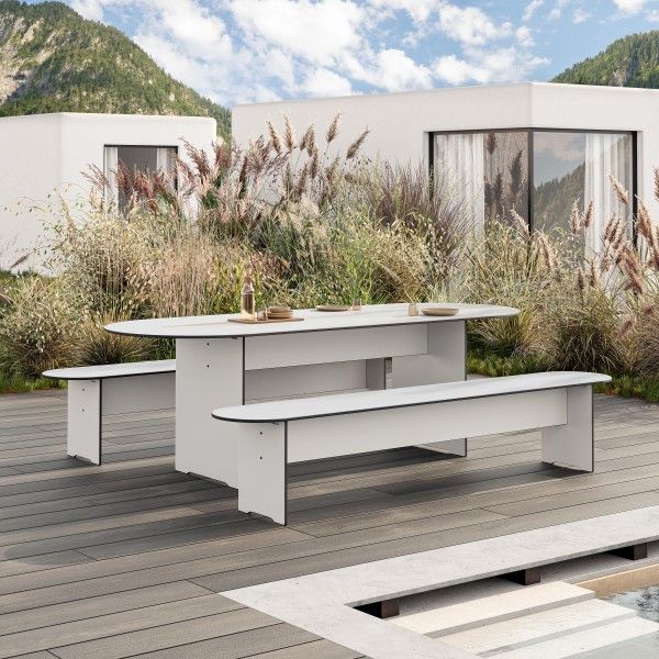 Riva Vario Round Tisch von Conmoto, weißer Gartentisch mit Bänken im Außenbereich.