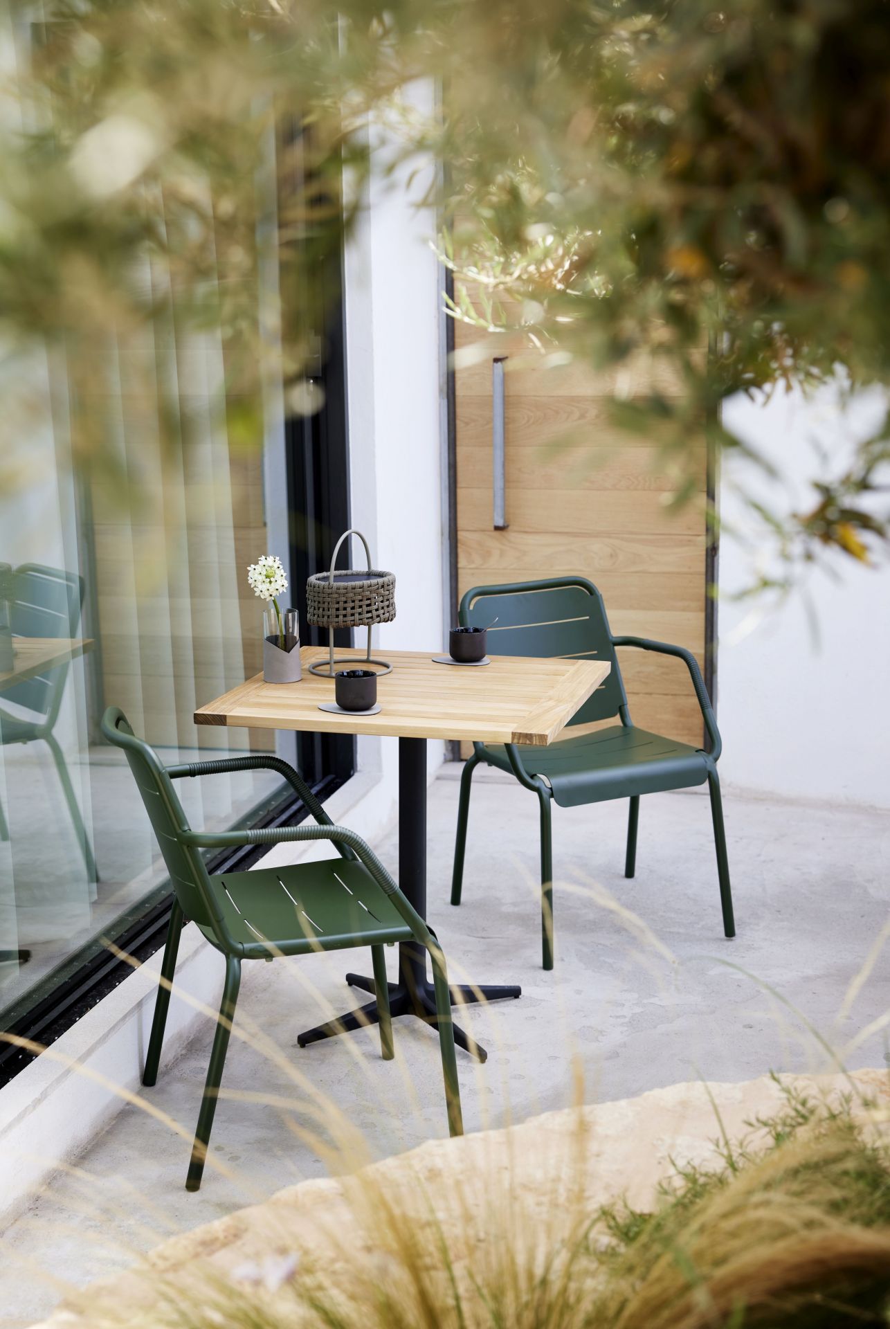 Cane-Line Copenhagen Armlehnstuhl 2er Set in Grün mit Tisch für den Außenbereich.