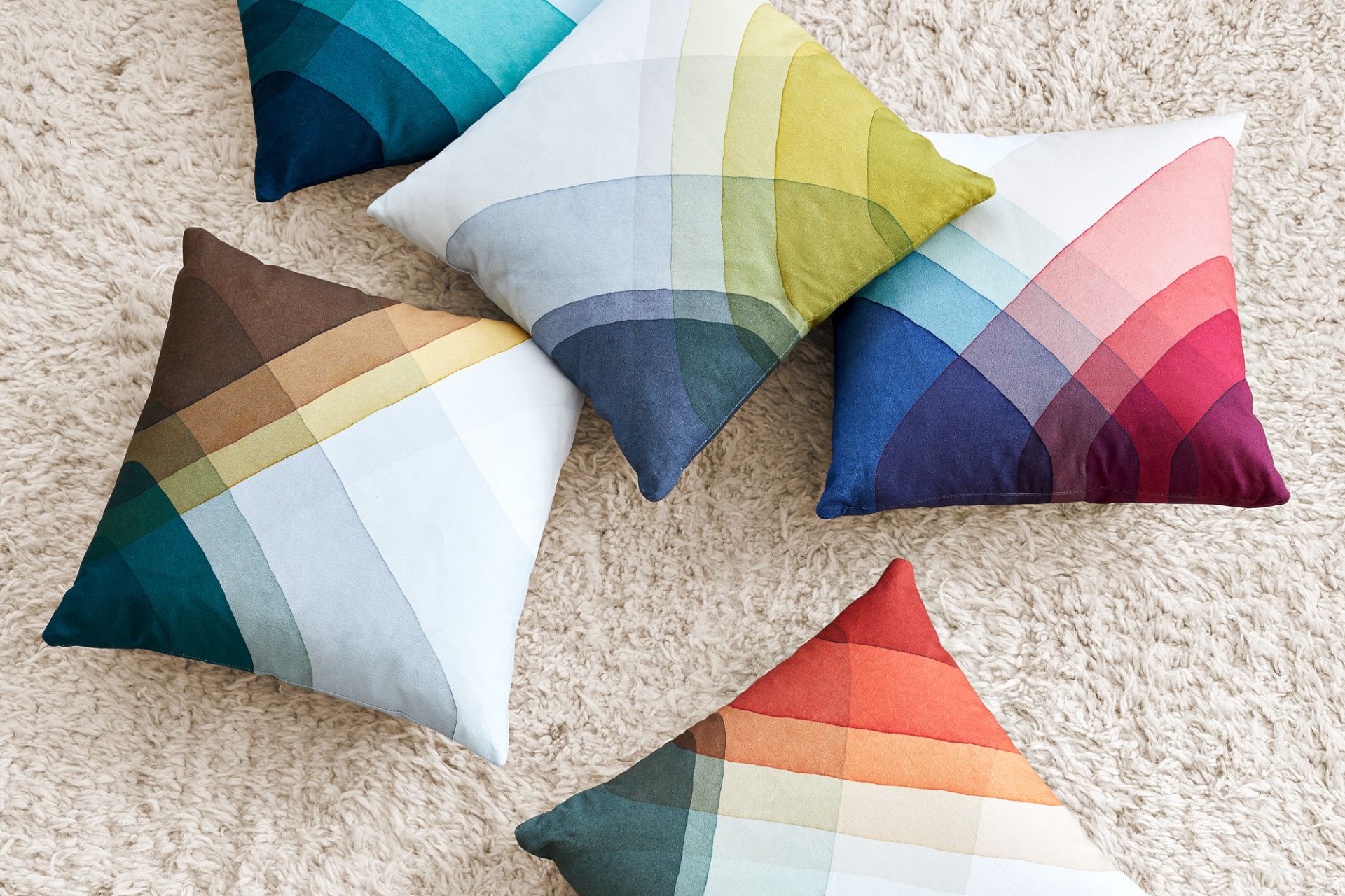 Mehrere bunte Heringbone Pillows Kissen von Vitra auf einem hellen Teppich, modernes Wohndesign.