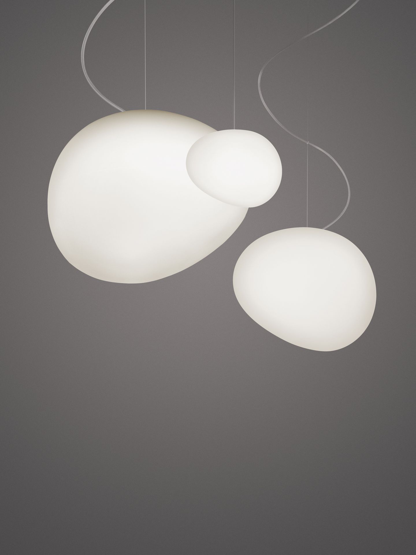 Gregg Pendelleuchte von Foscarini: Drei organisch geformte, weiße Hängelampen mit sanftem Licht.