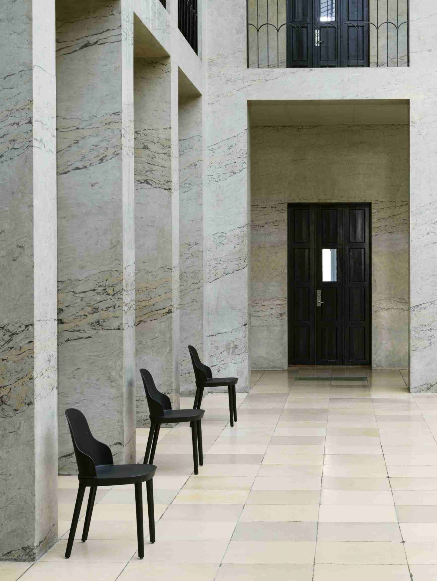 Drei schwarze Allez Chair Stühle von Normann Copenhagen in einem eleganten Innenraum.