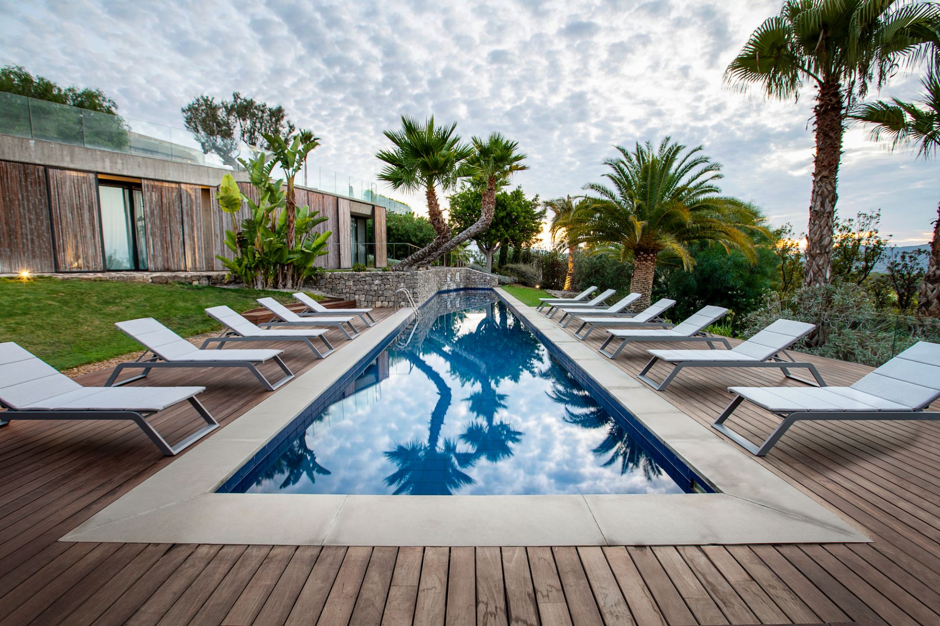 Sonnenliegen am Pool mit Cane-Line Outdoor Kissen für entspannte Stunden im Freien.