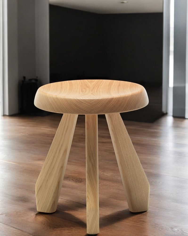 Cassina Méribel Hocker aus hellem Holz, runder Sitz und drei Beine. Designhocker.