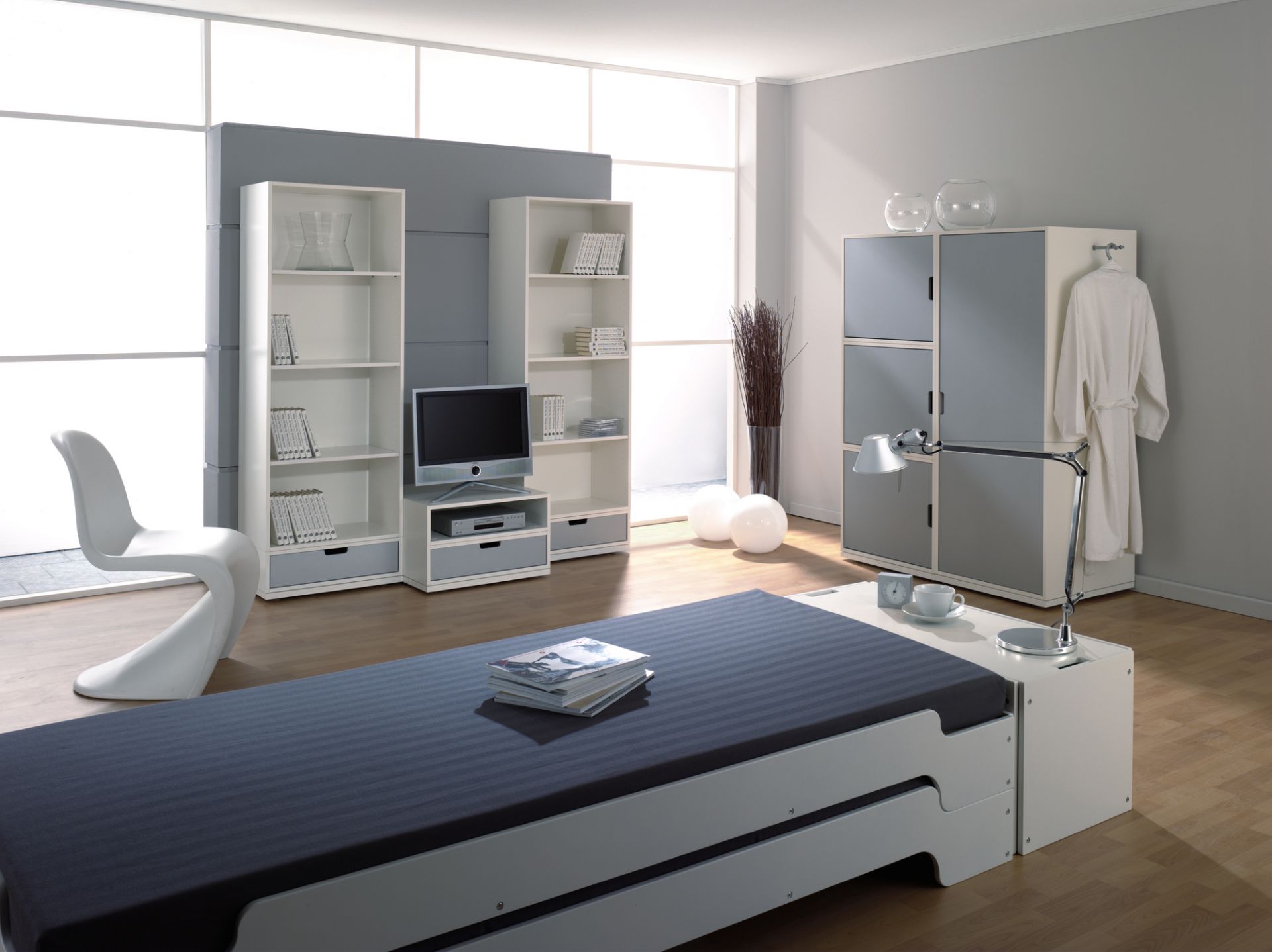 Modernes Schlafzimmer mit weißem Bettkasten von Müller Möbelwerkstätten und passenden weißen Möbeln.