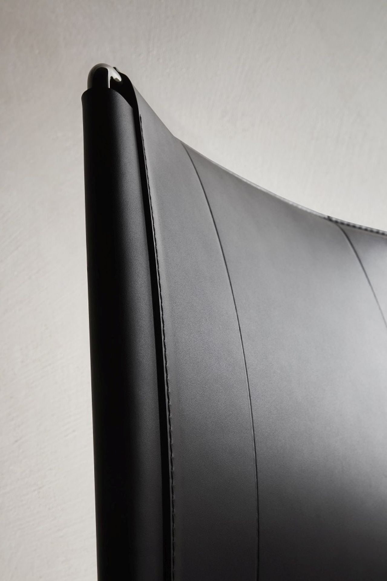Detailaufnahme des schwarzen Lederstuhls, möglicherweise ein Neil Leather Chair von MDF Italia.