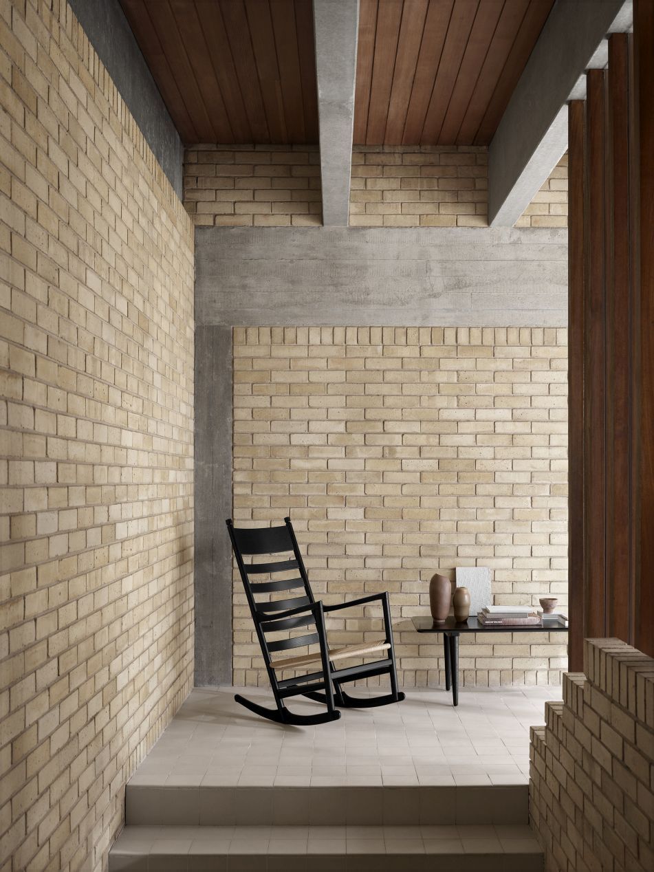 Schwarzer CH45 Schaukelstuhl von Carl Hansen & Søn mit Eiche geseift vor Backsteinwand.