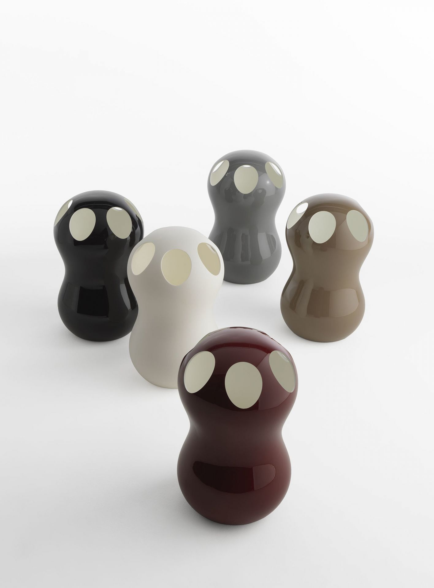 Fünf moderne Zontik Schirmständer von Casamania Horm in verschiedenen Farben auf weißem Hintergrund. Design Schirmständer mit Löchern.