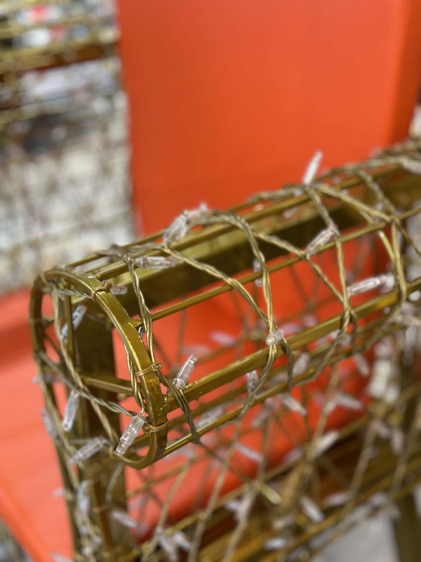 Detailaufnahme: Goldener Leuchtsessel mit Lichterkette, modernes Designmöbel für Wohnzimmer und Garten.