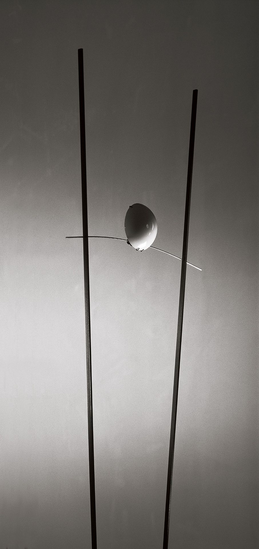 Ilios Stehleuchte von Ingo Maurer, silberfarben, mit zwei vertikalen Stäben und einer Kugel.