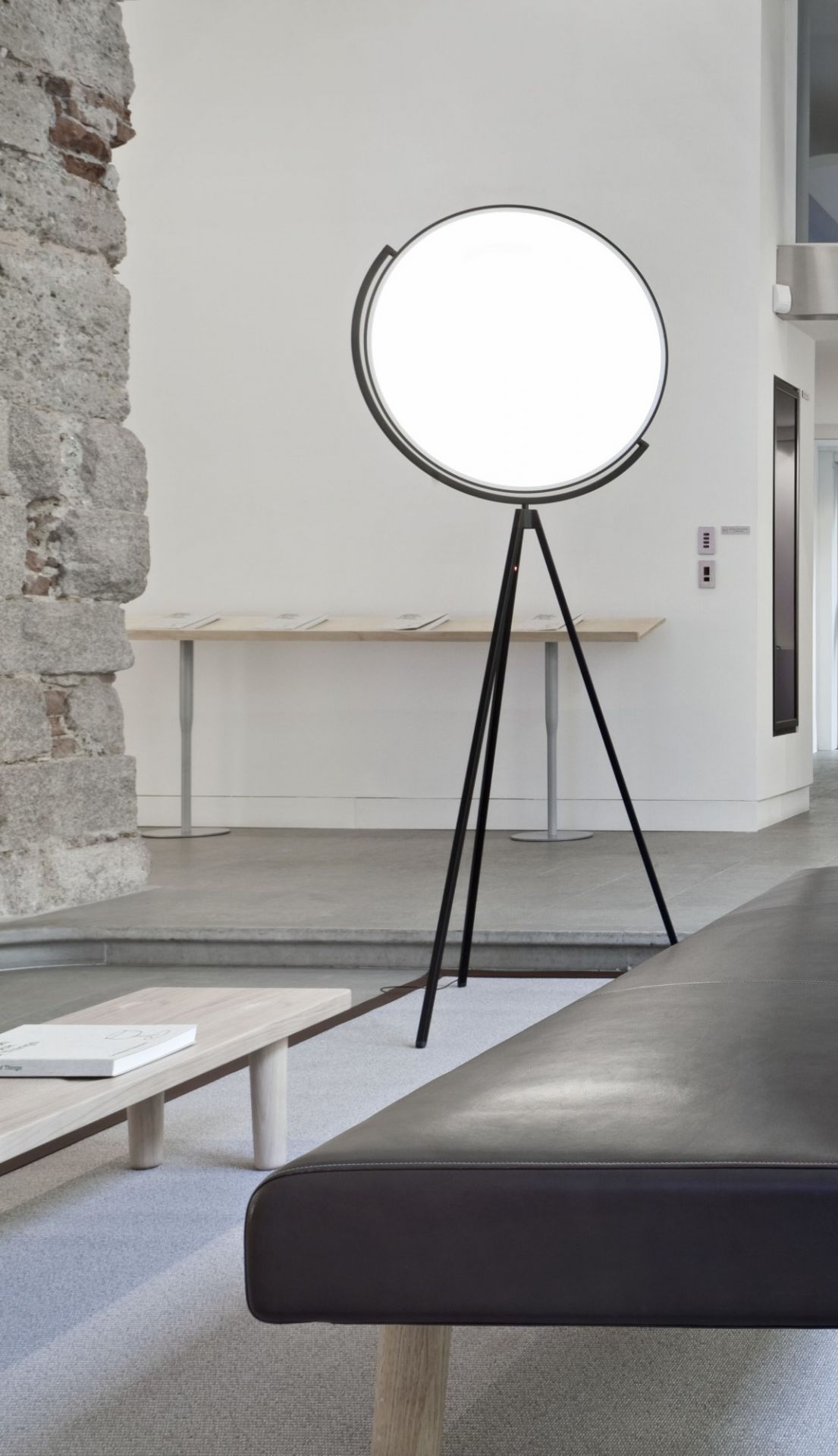 Superloon Stehleuchte von Flos: Moderne Stehlampe mit rundem, leuchtendem Schirm und schwarzem Stativfuß.