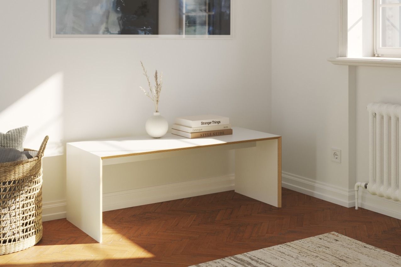 Weiße Bridge Sitzbank / Beistelltisch von Müller Möbelwerkstätten im minimalistischen Design mit Deko und Büchern.