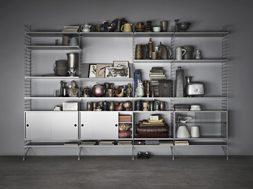 Graues String Furniture Regalsystem "Wohnzimmer KONFIGURATIONEN L8" mit Deko-Elementen und Schrankfächern.