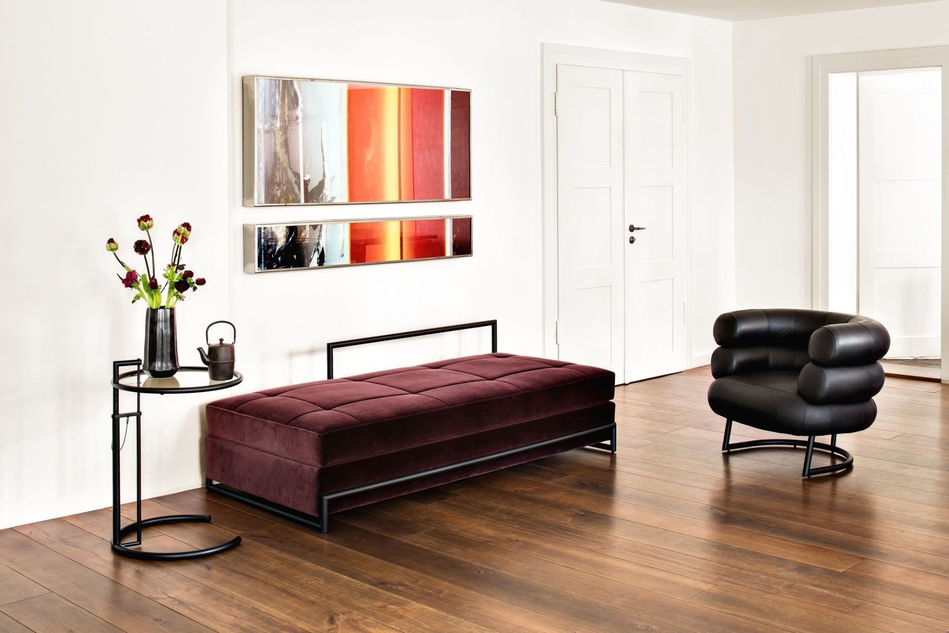 Burgundfarbenes Day Bed Classicon Liege mit schwarzem Gestell in modernem Wohnzimmer.