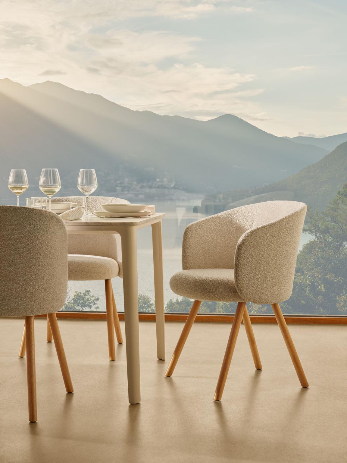 Beiger Mikado Armlehnstuhl von Vitra am Esstisch mit Blick auf Berglandschaft. Stuhl mit Holzbeinen.