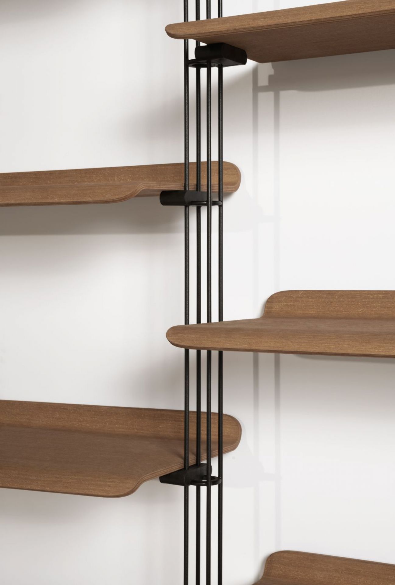 Detailansicht des Adam Holzregals von Kartell mit braunen Regalböden und schwarzem Metallgestell.