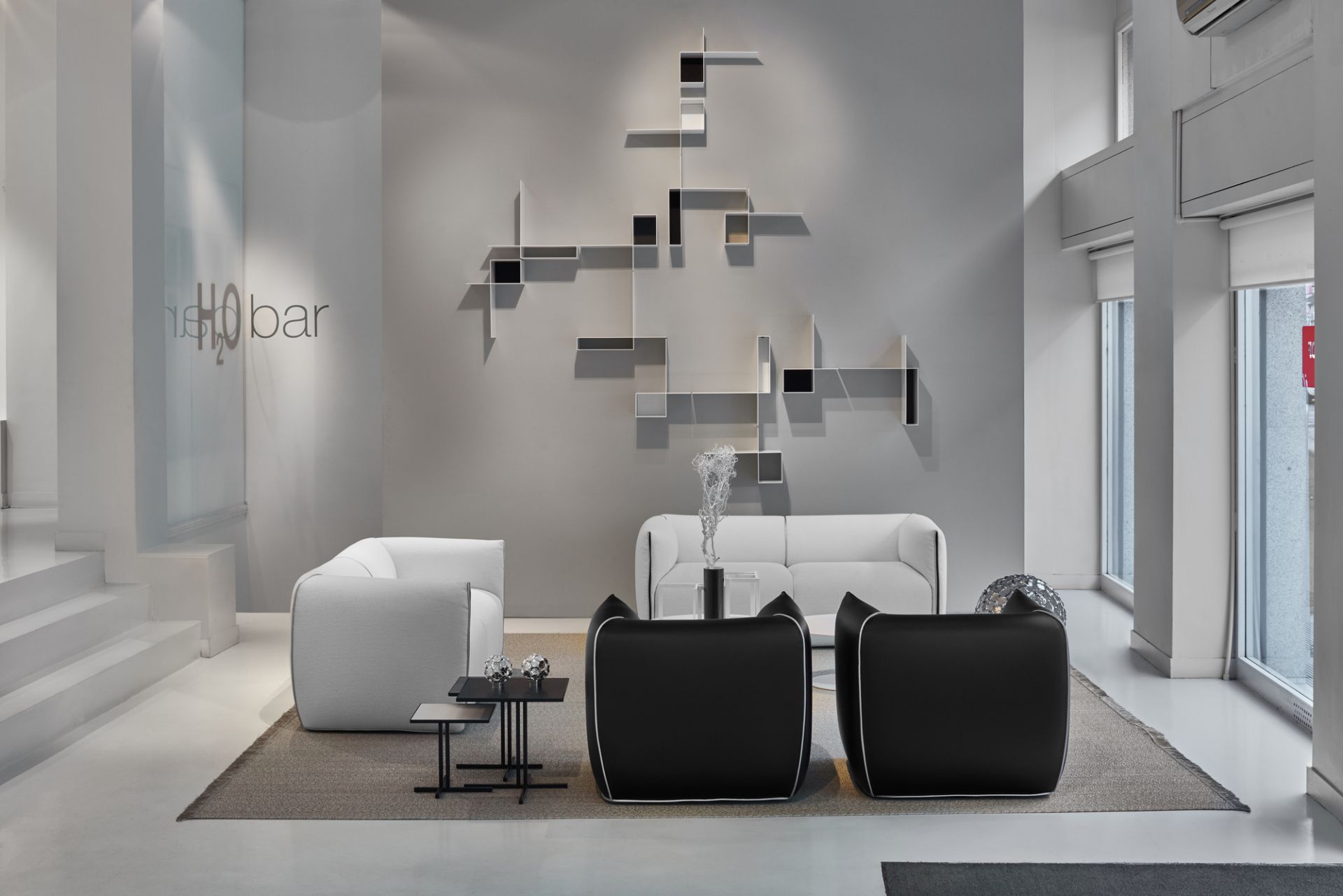 Wohnzimmer mit Randomissimo Regalsystem von MDF Italia an der Wand, Sofas und Sessel.