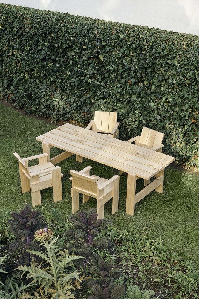Hay Crate Dining Chair Outdoor Stuhl aus hellem Holz mit passendem Tisch im Garten.