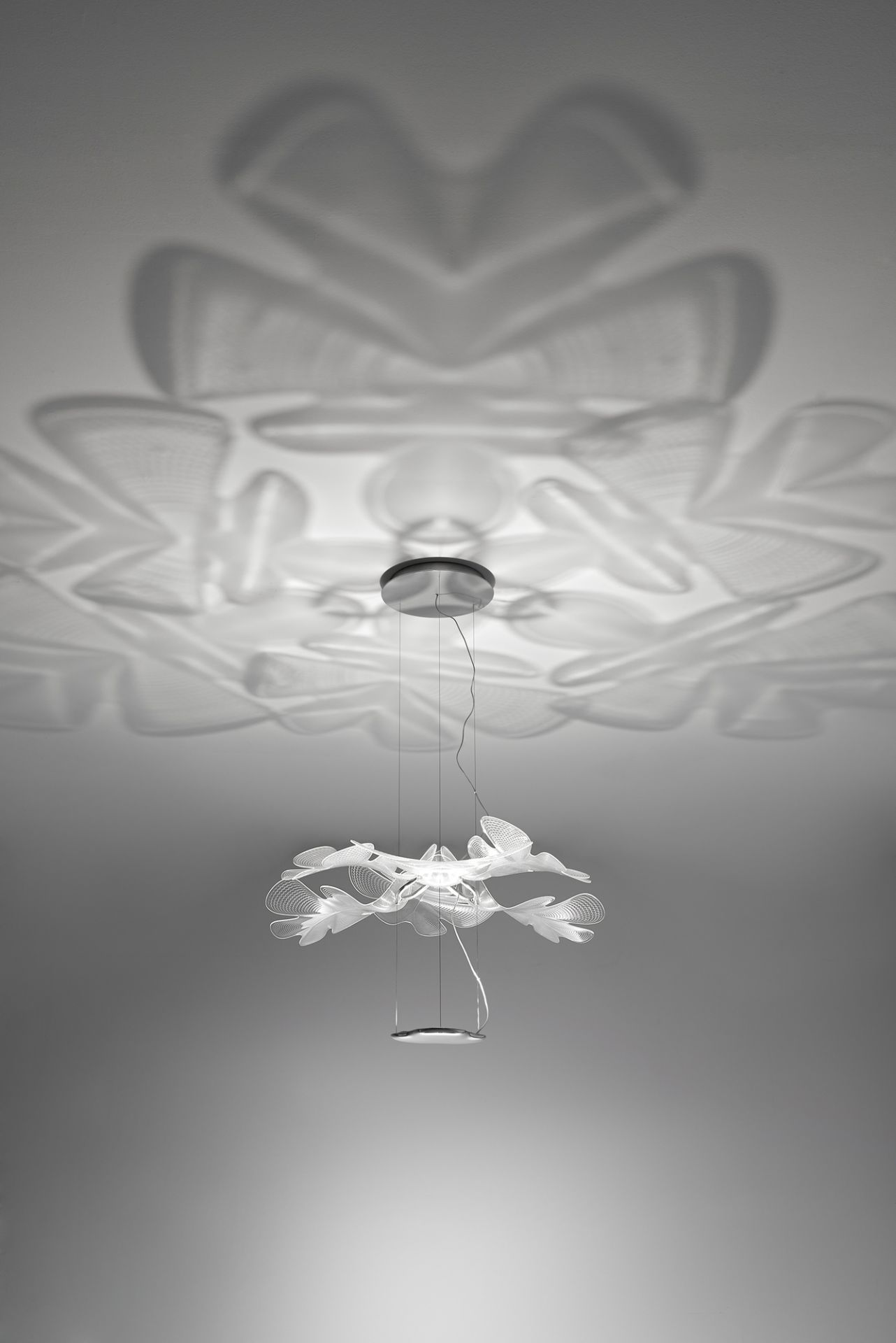 Chlorophilia Pendelleuchte von Artemide: Moderne Hängelampe mit Chromstruktur und transparenten Diffusoren, die ein einzigartiges Lichtspiel erzeugt.