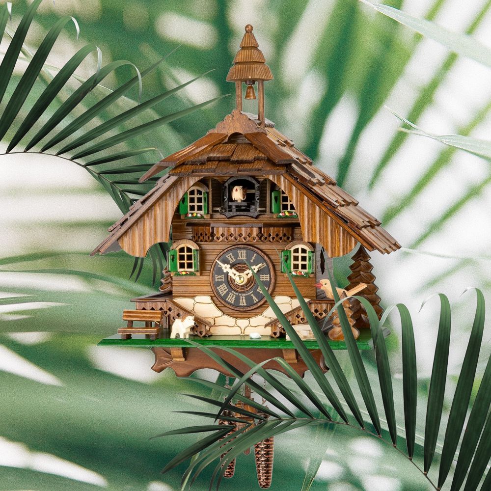 Detailaufnahme einer traditionellen Kuckucksuhr aus Holz mit Kuckuck, Ziffernblatt und dekorativen Elementen.