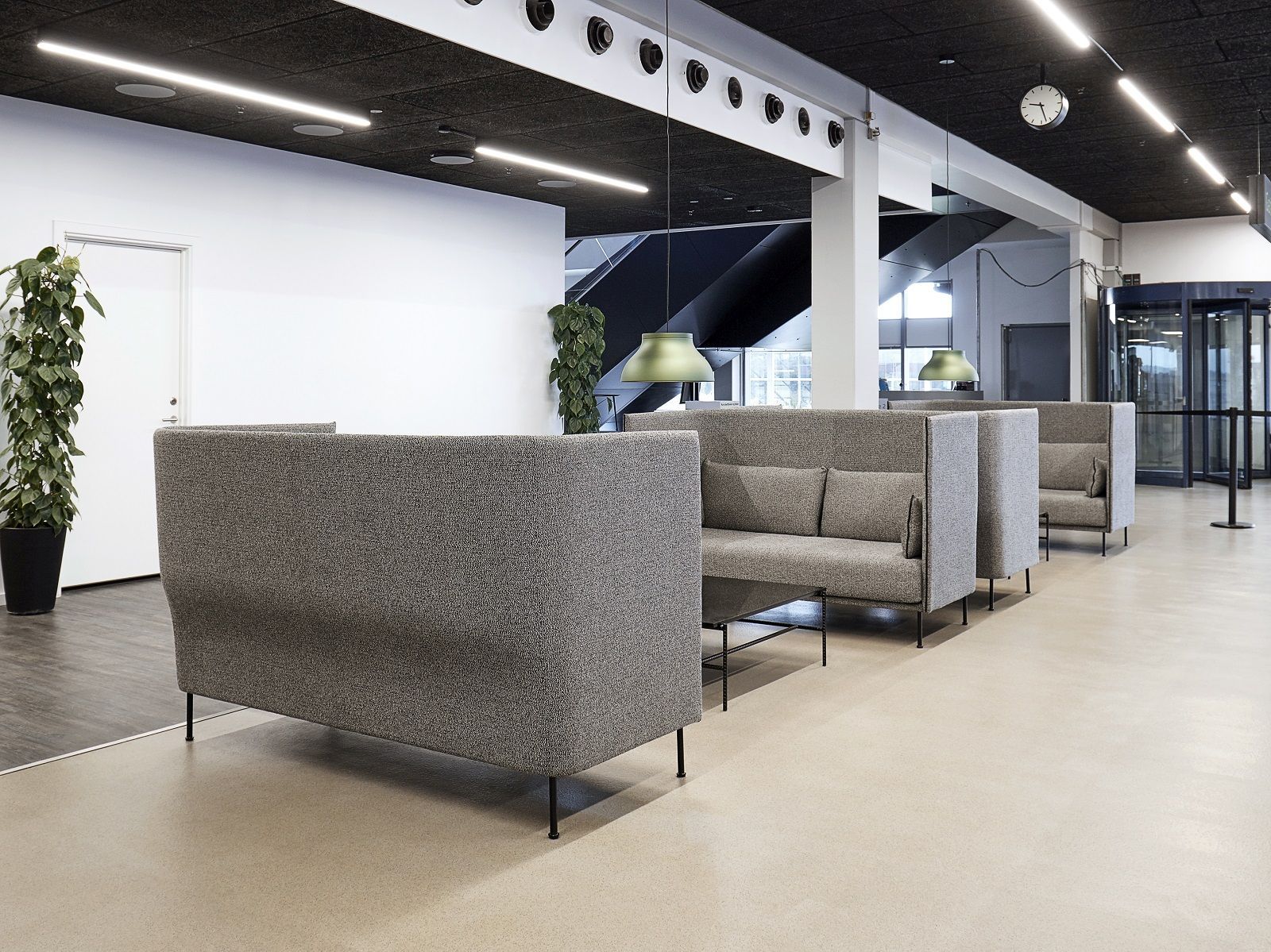 Graue Silhouette Sofas mit hoher Rückenlehne von Hay in einem modernen Büro.