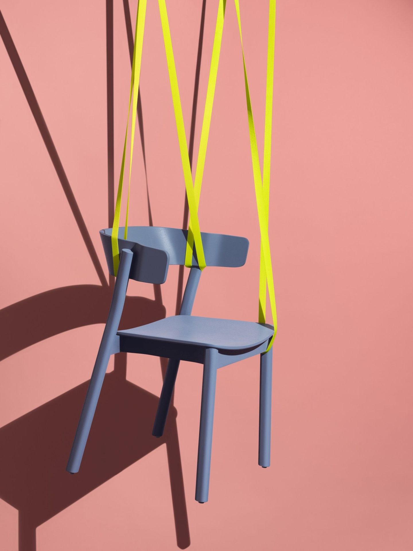 Enfold Chair Stuhl von Mizetto, hellblau, mit gelben Bändern vor rosa Hintergrund.