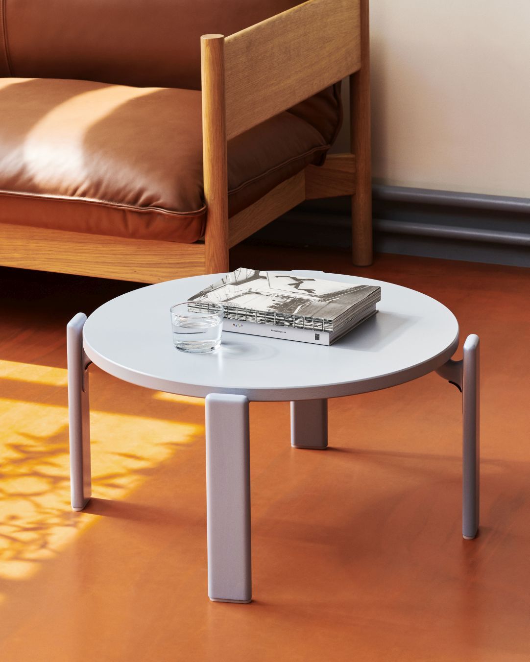 Runder, grauer Hay Couchtisch "Rey Coffee Table" mit Buch und Glas Wasser.