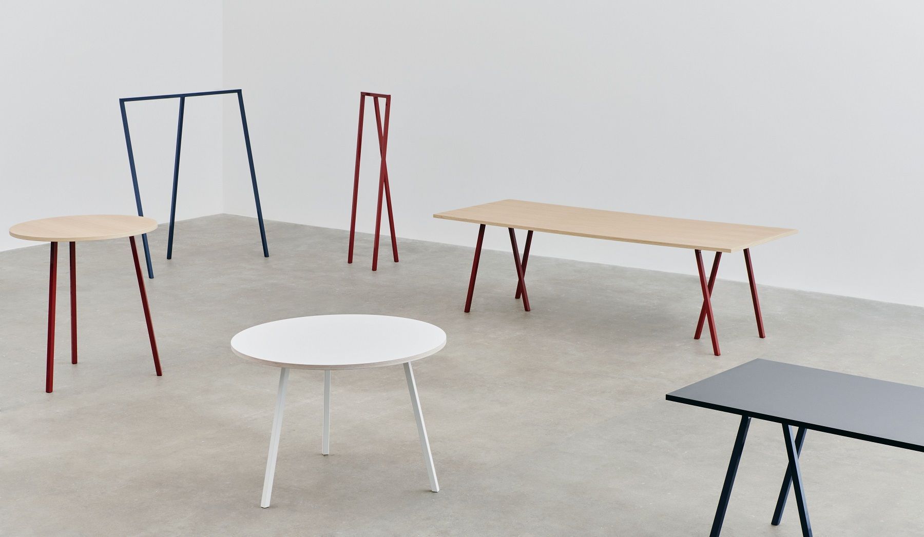 Mehrere Hay Loop Stand Tische in verschiedenen Farben und Formen, minimalistisches Design.