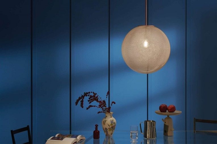 Bollicosa Lampe: Runde Pendelleuchte in Karamell über einem Esstisch, modernes Design.