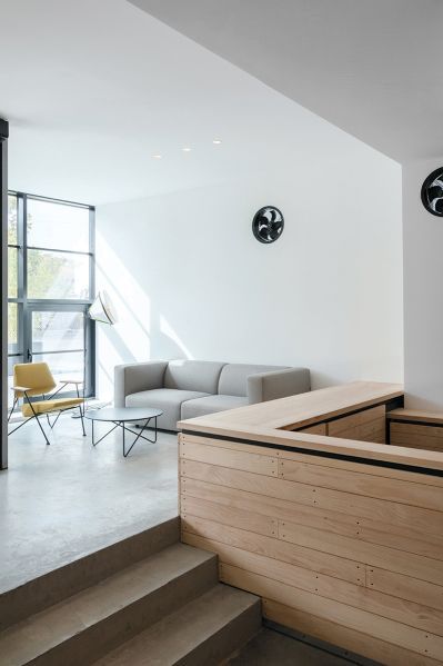 Helles Wohnzimmer mit grauem Match Sofa von Prostoria, Sessel und Couchtisch.