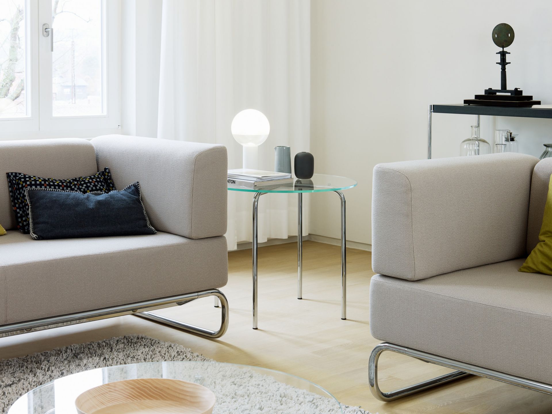 Heller Wohnraum mit zwei S 5001 Thonet Sesseln und Glasbeistelltisch, modernes Möbeldesign.