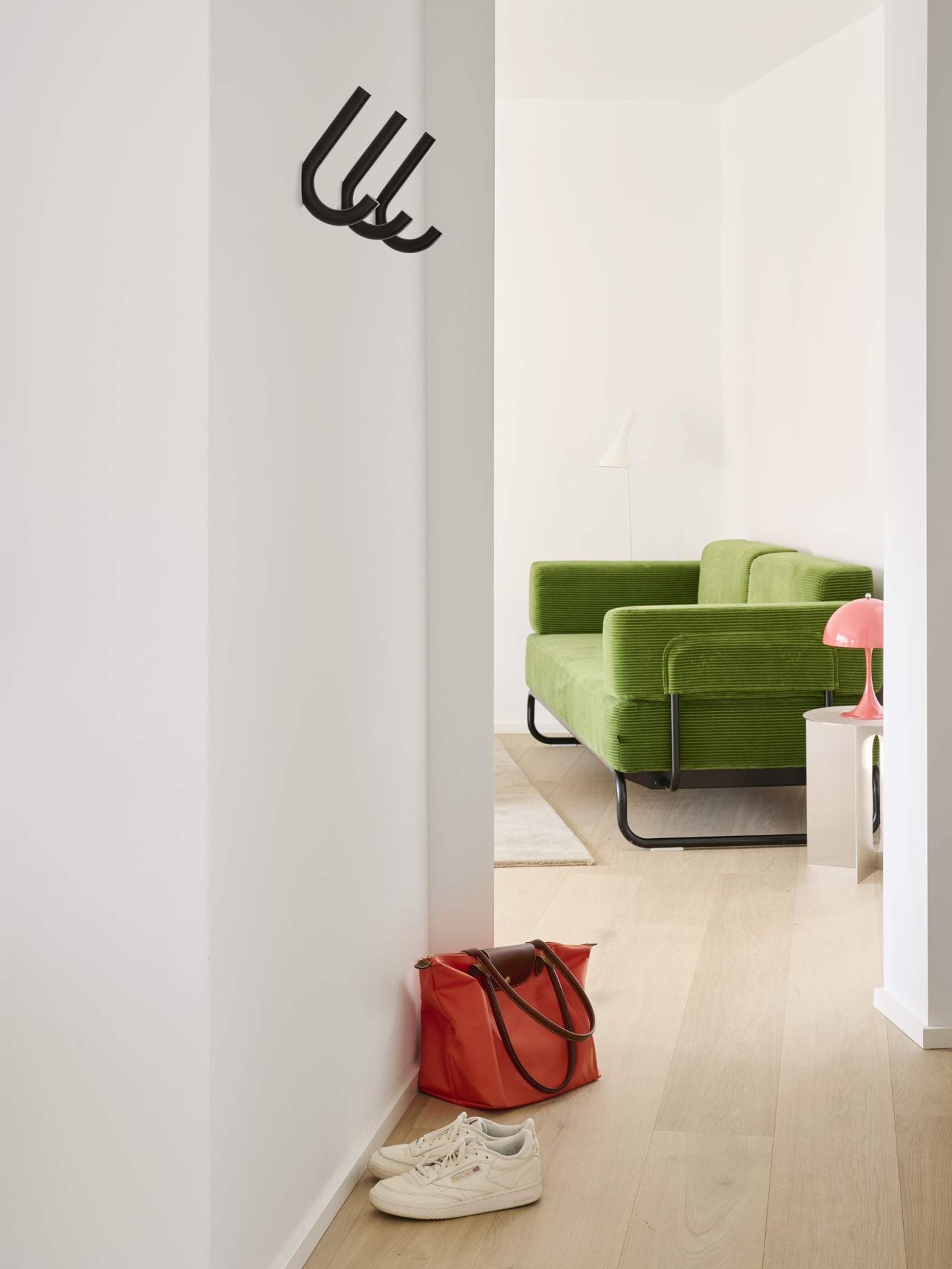 Schwarzer S 12 Wandhaken von Thonet an weißer Wand im Flur, minimalistisches Design.