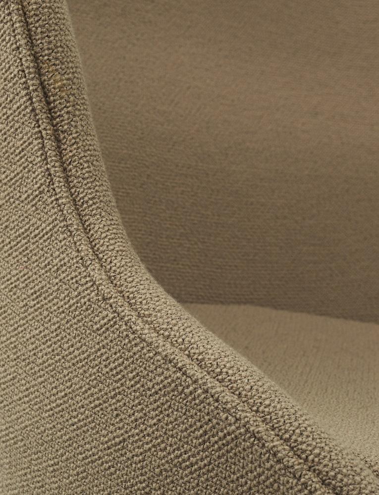 Detailaufnahme des beigen Stoffbezugs vom Hyg Lounge Chair Sessel von Normann Copenhagen. Hochwertige Polsterung und Textur.