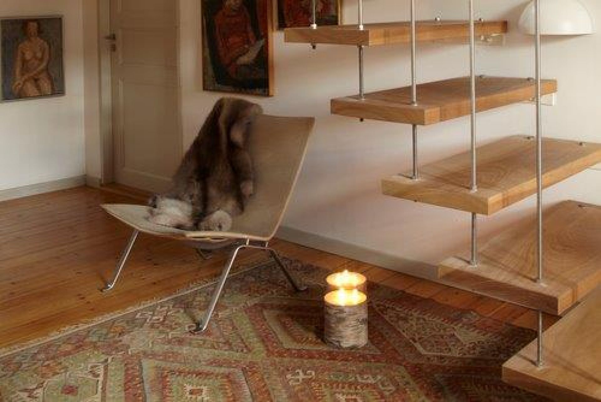 PK22 Sessel von Fritz Hansen mit Fell auf einem Teppich, neben einer Treppe.