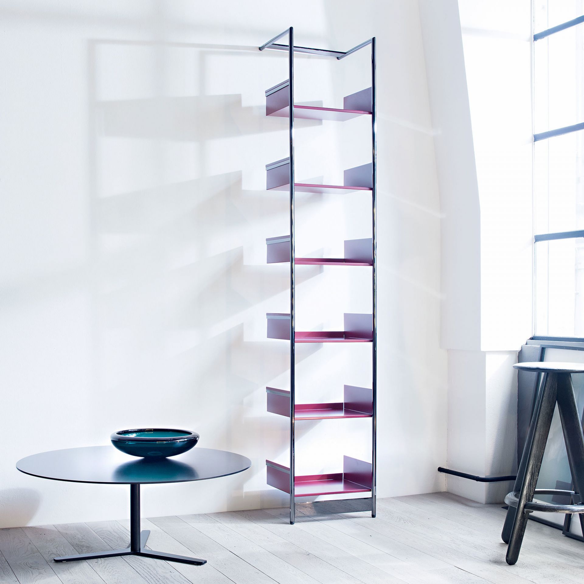 Tre90 Couchtisch von Mox mit runder Tischplatte und Stahlregal in modernem Wohnraum.