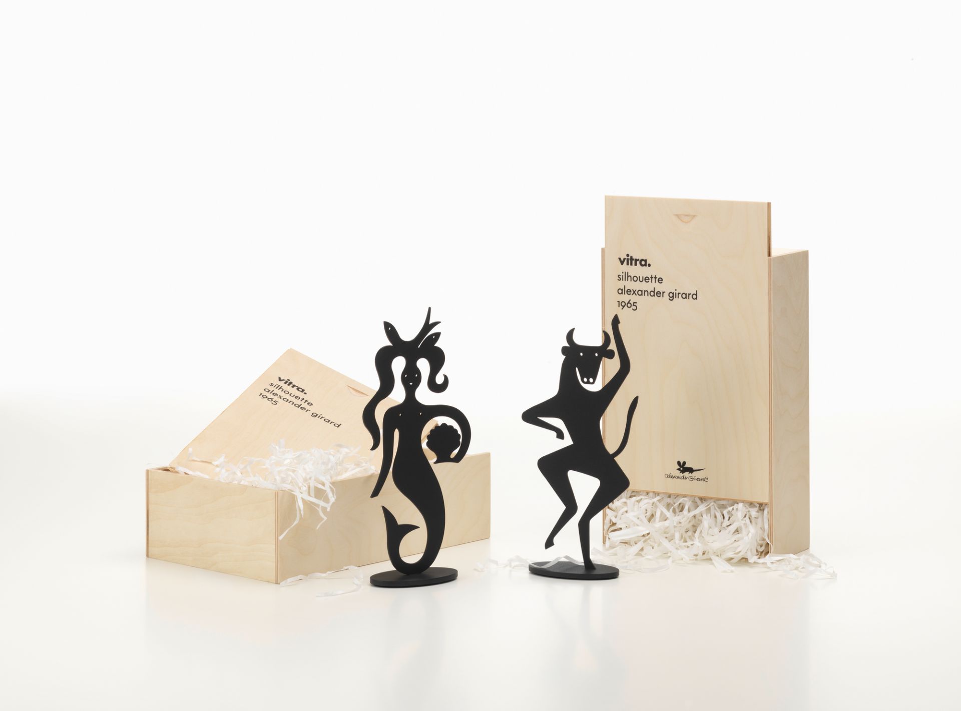 Vitra Silhouettes Figuren: Meerjungfrau und Stier aus Metall, präsentiert in Holzkiste mit Füllmaterial.