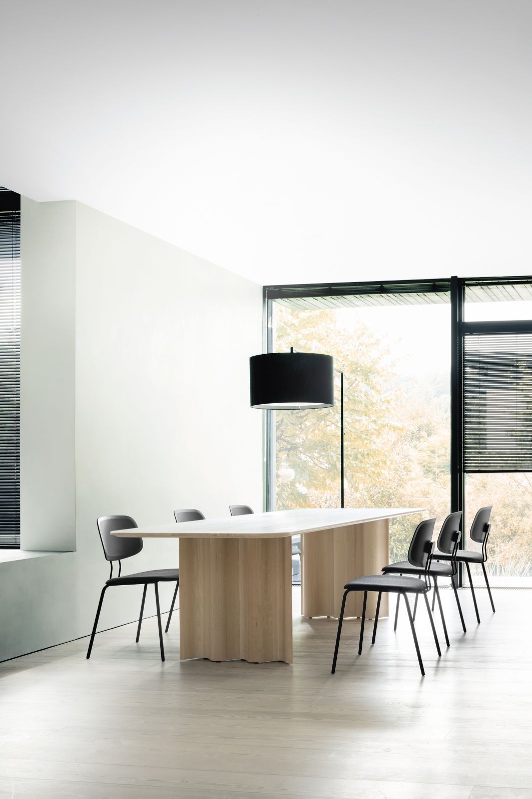 Helle Inneneinrichtung mit High Noon Stehleuchte in Weiß, Esstisch und Stühlen.