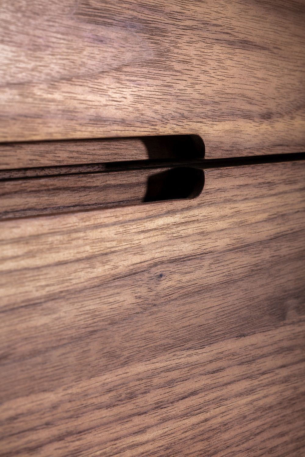 Detailaufnahme des Nightstand 64 Nachttischs mit Schubladen aus edlem, dunklem Holz.