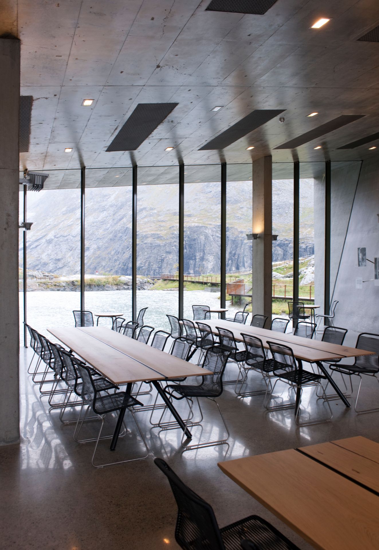 Innenaufnahme mit langen Tischen und vielen Panton One Stühlen mit Edelstahlgestell.